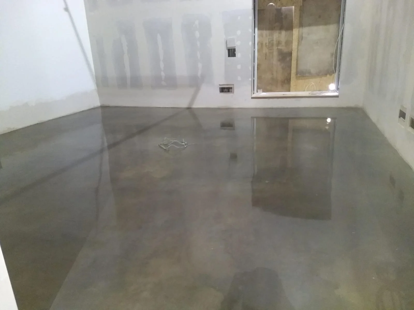 Polished concrete floor with smooth reflective finish in an interior space.